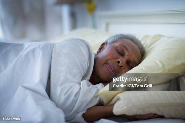 black woman sleeping in bed - acostado de lado fotografías e imágenes de stock