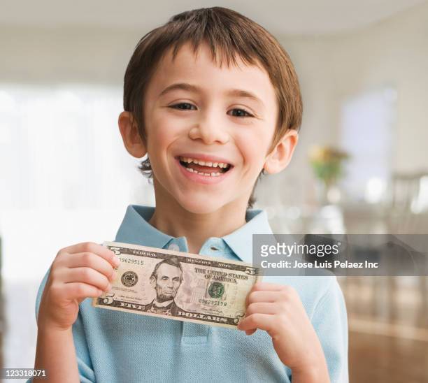 grinning caucasian boy holding five dollar bill - 5 dollar schein stock-fotos und bilder