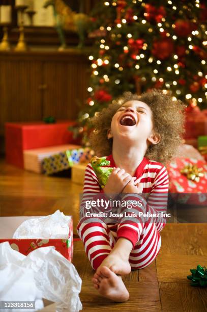 excited mixed race boy opening christmas gift - christmas gift fotografías e imágenes de stock