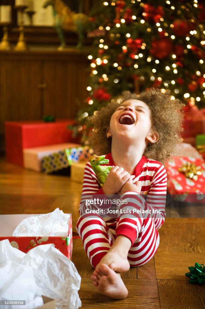 Excited mixed race boy opening Christmas gift