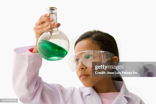 hispanic girl looking at liquid in beaker - beaker white background stock pictures, royalty-free photos & images