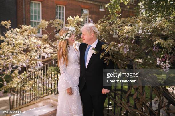 In this handout image released by 10 Downing Street, Prime Minister Boris Johnson poses with his wife Carrie Johnson in the garden of 10 Downing...
