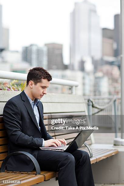 mixed race businessman using laptop on city bench -  "suprijono suharjoto" or "take a pix media" stock pictures, royalty-free photos & images