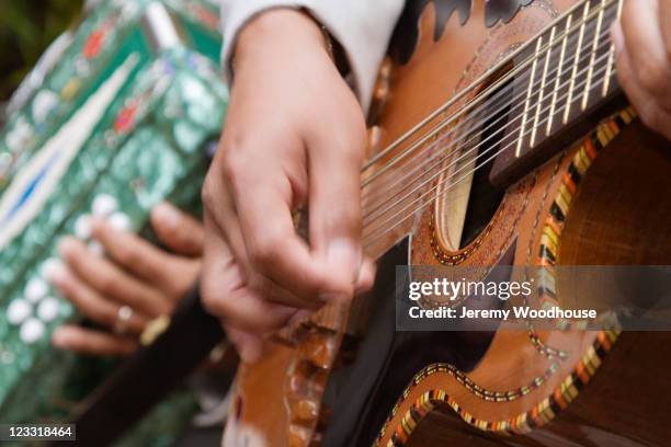 close up of hispanic man playing guitar - música latinoamericana fotografías e imágenes de stock