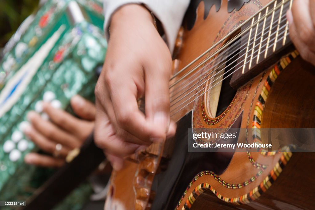 Close up of Hispanic man playing guitar