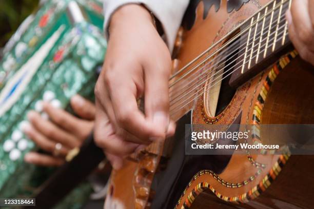 close up of hispanic man playing guitar - arts culture and entertainment foto e immagini stock