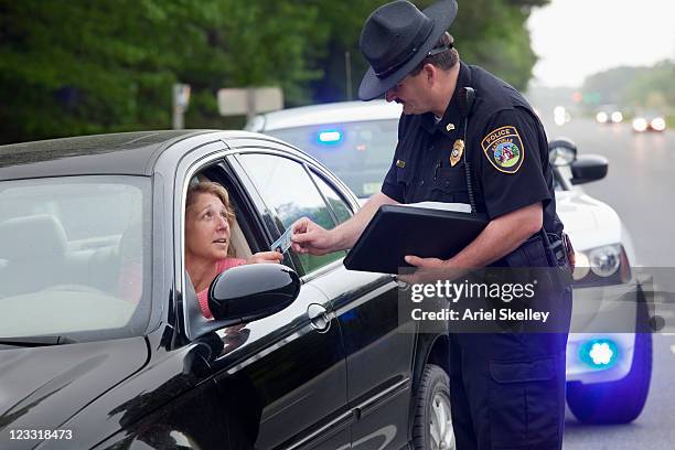 policeman giving driver speeding ticket - police hat stock pictures, royalty-free photos & images