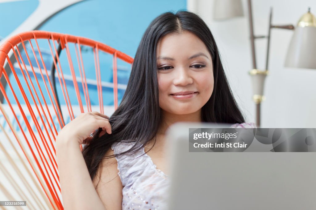 Smiling Vietnamese woman using laptop