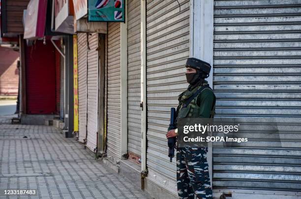 Paramilitary trooper wearing a face mask stands alert at a closed market during a lockdown imposed to prevent the spread of coronavirus in Srinagar....