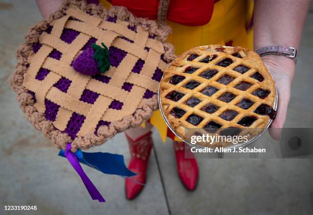 Buena Park, CA Cat Madinger, who created her own character that she named Sweetie Pie, shows off her costume accessory; boysenberry pie next to a...