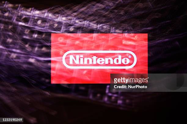 Nintendo logo displayed on a phone screen and a keyboard are seen in this multiple exposure illustration photo taken in Krakow, Poland on May 30,...