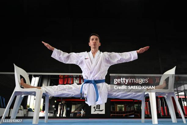 This picture taken on May 11, 2021 shows Afghan-born refugee and karate competitor Asif Sultani stretching as he trains at a gym on the outskirts of...
