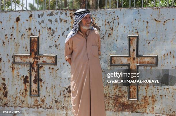 Picture taken on May 18, 2021 shows Ali Mansour, the caretaker of the cemetery of the Protestant Christians in Baghdad, where British archaeologist,...