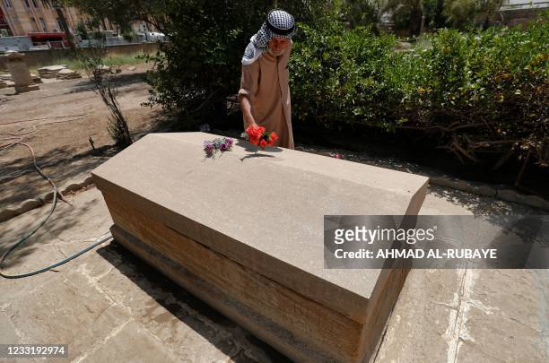 Iraqi caretaker Ali Mansour places a flower on the grave of British archaeologist, writer, diplomat and spy Gertrude Bell in the cemetery of the...