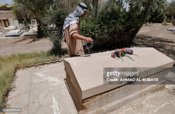 Iraqi caretaker Ali Mansour places a flower on the grave of British archaeologist, writer, diplomat and spy Gertrude Bell in the cemetery of the...