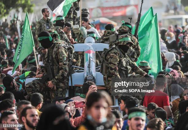 Palestinians gather as Hamas militants with weapons take part during the parade on the street in the northern Gaza Strip.