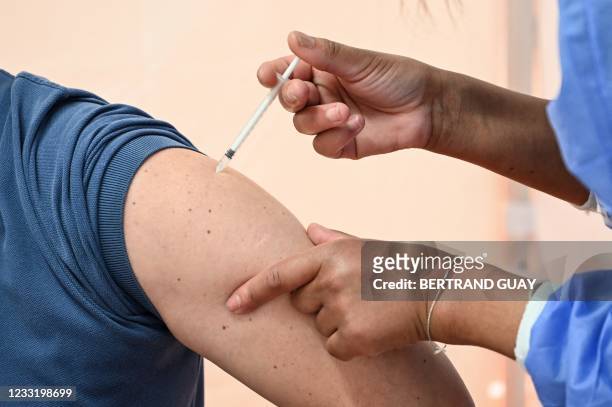Patient receives a dose of the Pfizer-BioNTech vaccine at the temporary Covid-19 vaccination centre in a gymnasium in Saint-Maur-des-Fossés, outside...