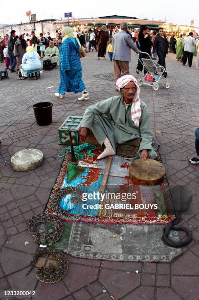 Photo prise en mai 2006 d'un charmeur de serpents sur la place Jemaa El Fna de Marrakech, lieu où se déroulent de nombreux spectacles et numéros :...