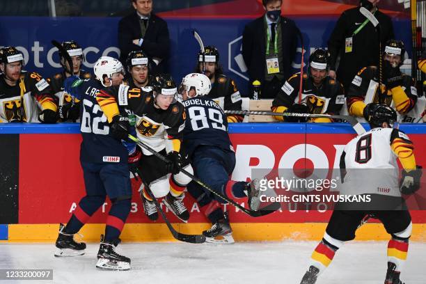 Germany's defender Jonas Muller and US' forward Kevin Labanc and US' forward Justin Abdelkader vie during the IIHF Men's Ice Hockey World...