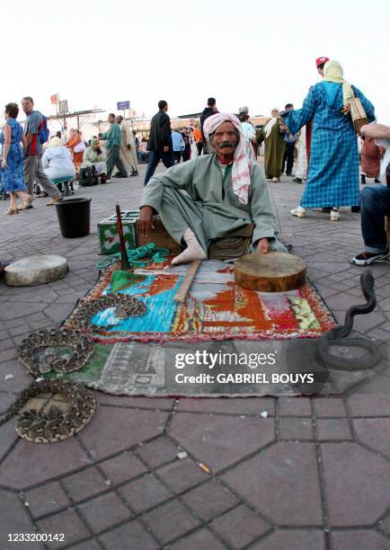 Photo prise en mai 2006 d'un charmeur de serpents sur la place Jemaa El Fna de Marrakech, lieu où se déroulent de nombreux spectacles et numéros :...