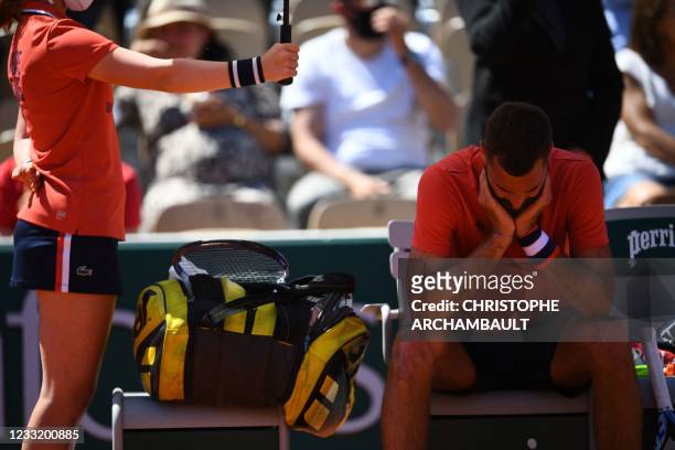France's Benoit Paire reacts during a break during the men's singles first round tennis match against Norway's Casper Ruud on Day 2 of The Roland...