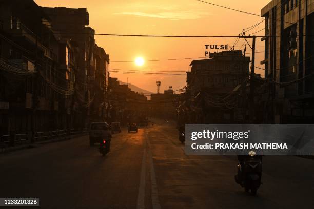 Motorists make their way along a road during a lockdown imposed to curb the spread of the Covid-19 coronavirus, in Kathmandu on May 31, 2021.