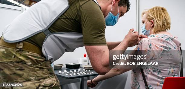Serviceman injects a dose of Covid-19 vaccine to a woman at the vaccination site in Molenbeke, Arnhem, on May 31, 2021. - Defense is temporarily...