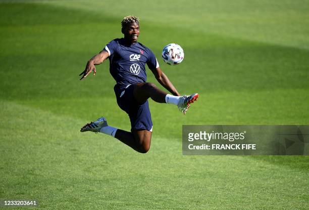 France's midfielder Paul Pogba controls the ball during a training session in Clairefontaine-en-Yvelines on May 31, 2021 as part of the team's...