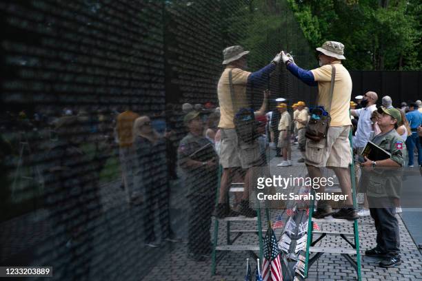 Man creates a rubbing of an engraved name during Memorial Day events at the Veterans Memorial on the National Mall on May 31, 2021 in Washington, DC.