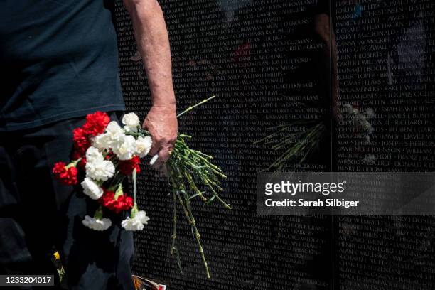 Man carries flowers during Memorial Day events at the Veterans Memorial on the National Mall on May 31, 2021 in Washington, DC.