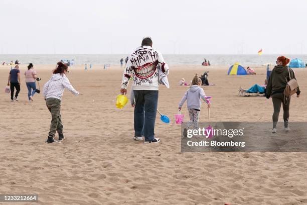 Family walk across the sand on the beach in Skegness, U.K., on Monday, May 31, 2021. U.K. Health Secretary Matt Hancock said people who want to go on...