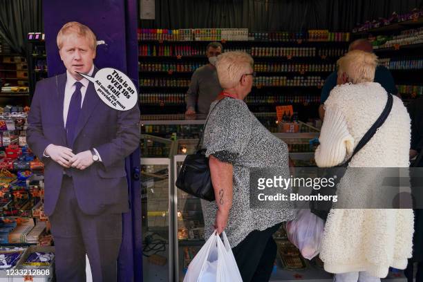 Visitors at a market stall alongside a novelty life-sized cut-out of Boris Johnson, U.K. Prime minister, in Skegness, U.K., on Monday, May 31, 2021....