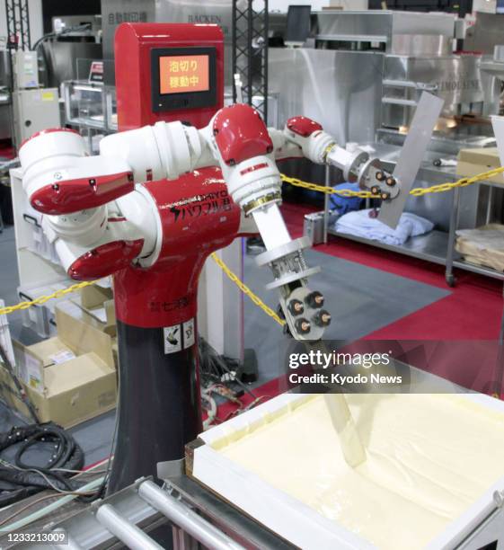 A robot mixes sponge cake dough and puts it into a cake pan at the