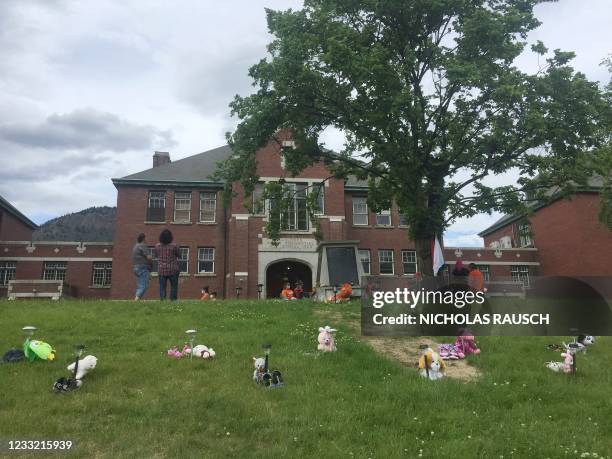 Flowers and tributes are brought to the Kamloops Indian Residential School Monument area on May 31, 2021 in Kamloops, British Columbia, in memory of...