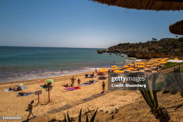 Beachgoers relax on Oura Beach in Albufeira, Portugal, on Saturday, May 29, 2021. Portugal is likely to raise its economic growth forecast for this...