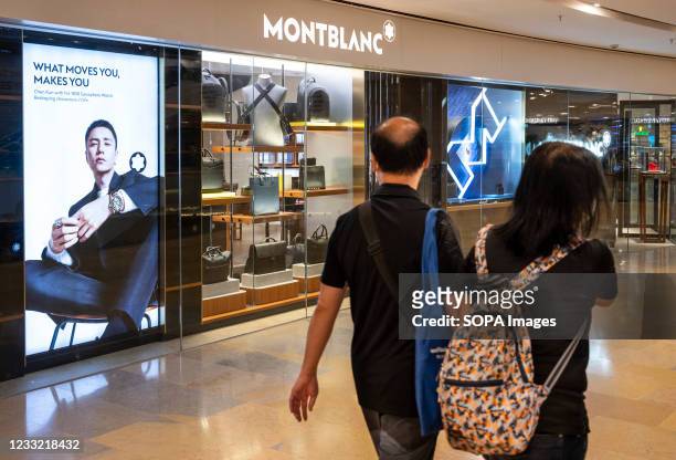 Couple walk past the German manufacturer of luxury writing instruments, watches, jewellery Montblanc store seen Hong Kong.