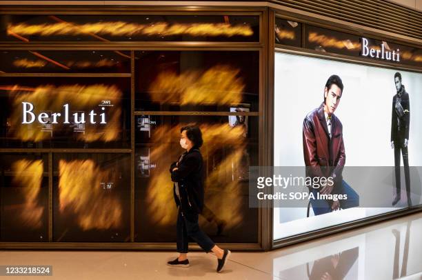Shopper walks past the Italian fashion brand Berluti store seen in Hong Kong.