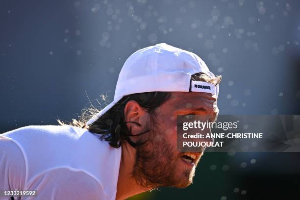 France's Lucas Pouille reacts as he returns the ball to Uruguay's Pablo Cuevas during their men's singles first round tennis match on Day 3 of The...