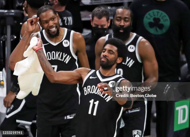 The Nets Kyrie Irving waves a towel in celebration as the final seconds ticked off the clock, his teammates Kevin Durant and James Harden are behind...