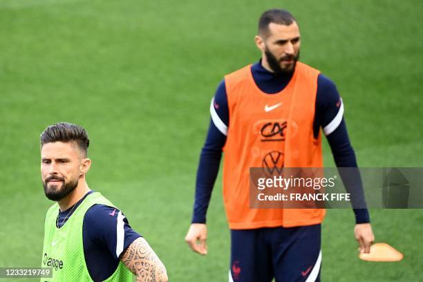 France's forward Olivier Giroud looks on past France's forward Karim Benzema during a training session at the Allianz Riviera Stadium in Nice,...