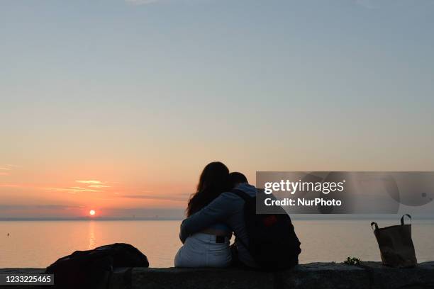 Couple watches a sunset from Dun Laoghaire West Pier. On Tuesday, 1 June 2021, in Dun Laoghaire, Dublin, Ireland.