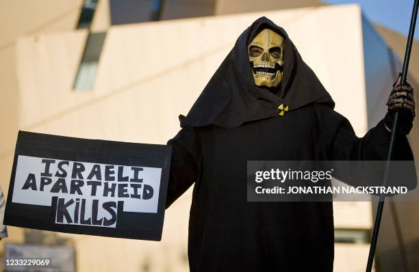 Left-wing activist protests against the construction of settlements in the West Bank outside the Bar Ilan university in Ramat Gan, near Tel Aviv, as...