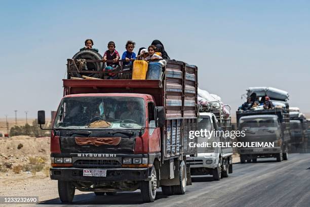 Syrian families sit in a truck after being released from the Kurdish-run Al-Hol camp, which holds relatives of suspected Islamic State group...