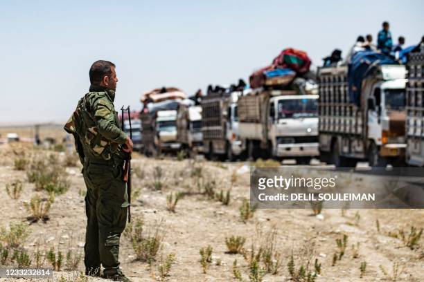 Syrian families sit in a truck after being released from the Kurdish-run Al-Hol camp, which holds relatives of suspected Islamic State group...