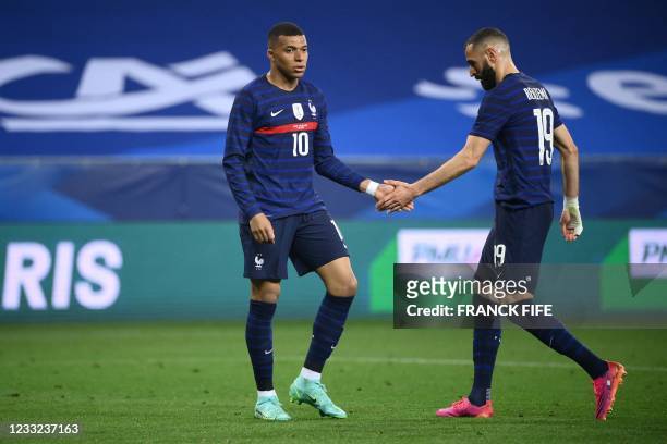 France's forward Kylian Mbappe and France's forward Karim Benzema check hands during the friendly football match between France and Wales at the...