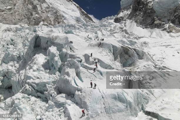This aerial picture taken on April 18, 2021 shows climbers crossing the Khumbu icefall of Mount Everest, as seen from the Everest Base Camp, some 140...
