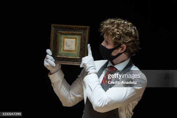 Staff member holds a drawing titled 'Head of a Bear' by Leonardo da Vinci , estimate: Â£8 000 - 12 000, during a photo call at Christie's auction...