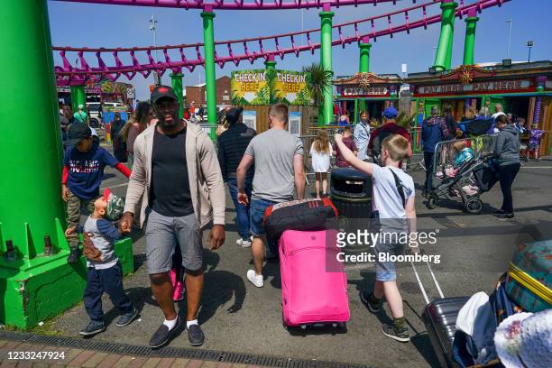 Visitors walk underneath rollercoaster rails at a theme park in Skegness, U.K., on Monday, May 31, 2021 .U.K. Health SecretaryMatt Hancocksaid people...