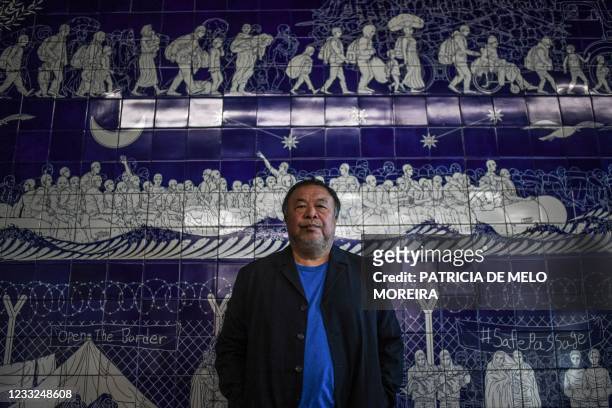 Chinese artist Ai Weiwei poses in front of one of his artworks that is made with Portuguese traditional 'azulejo' tiles, at his exhibition "Rapture"...