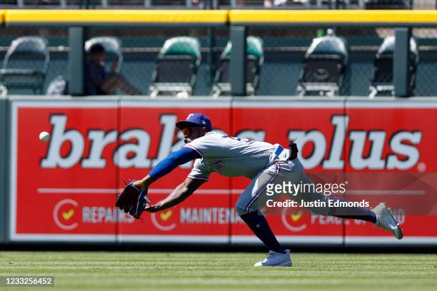 Center fielder Adolis Garcia of the Texas Rangers makes a diving catch during the sixth inning against the Colorado Rockies at Coors Field on June 3,...